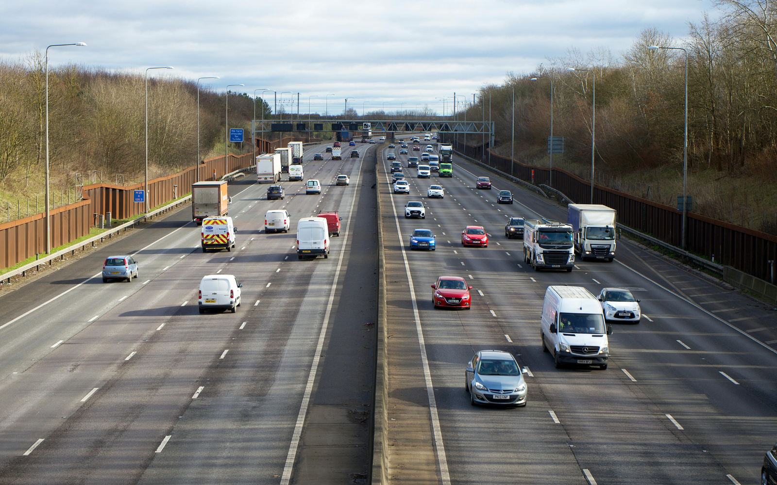 Traffic running on a multi lane UK motorway seen from an overbridge.