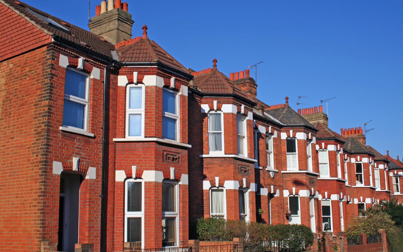 A row of furnished terraced houses on a residential street in an English town.