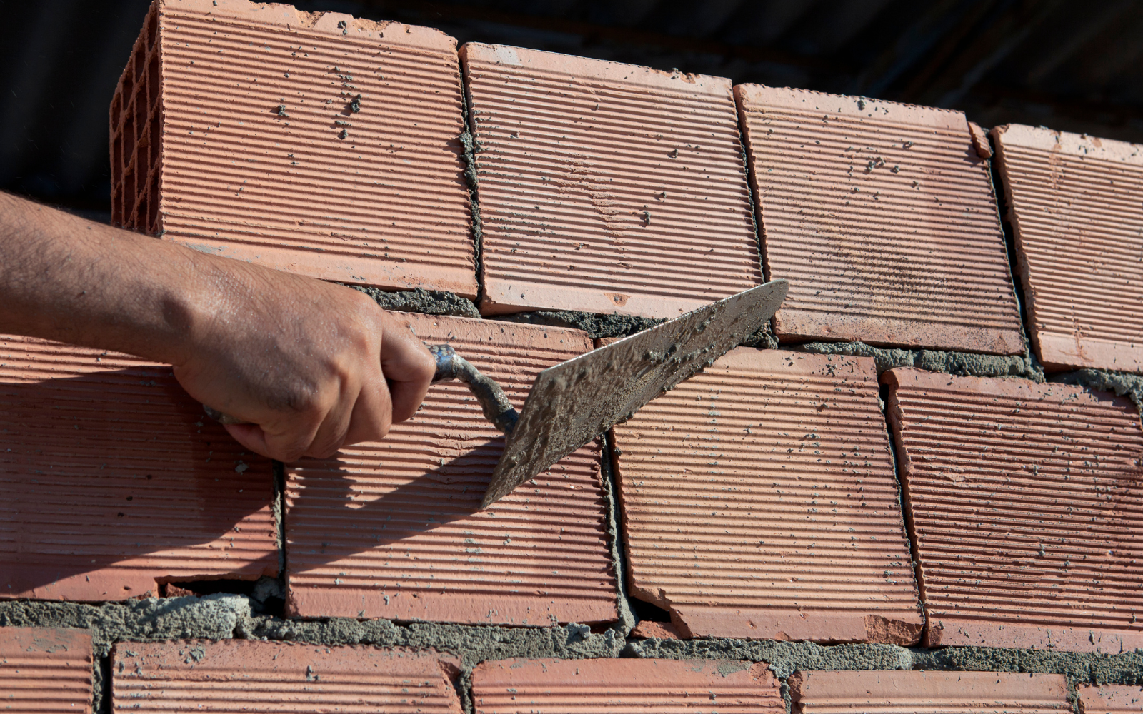 A stonemason dressing a sandstone block with a mallet and chisel.