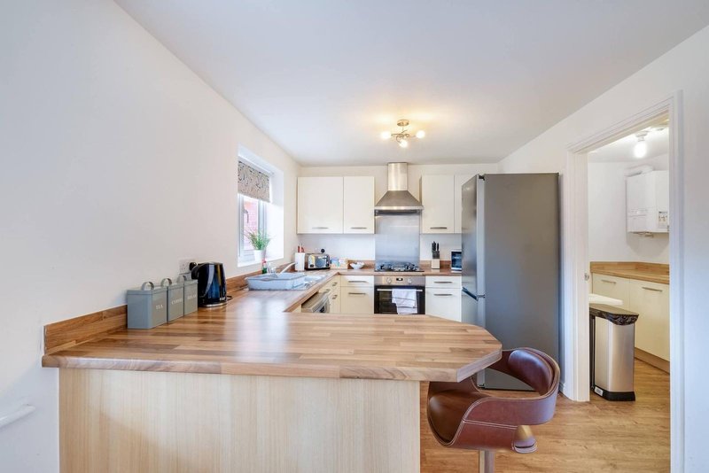 Modern kitchen with wooden island, stainless steel appliances, and dining area