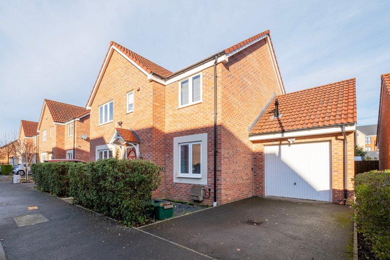 Modern brick semi-detached house with white garage door, driveway and front garden