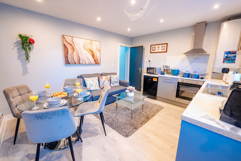 Open-plan kitchen and dining area with blue accents, dining table, and modern appliances