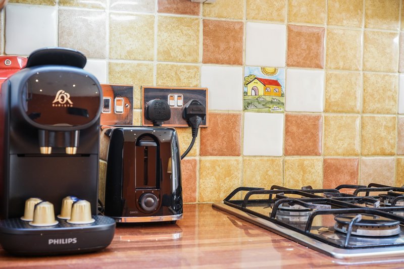 Kitchen countertop with coffee machine, toaster, gas hob and decorative tiles