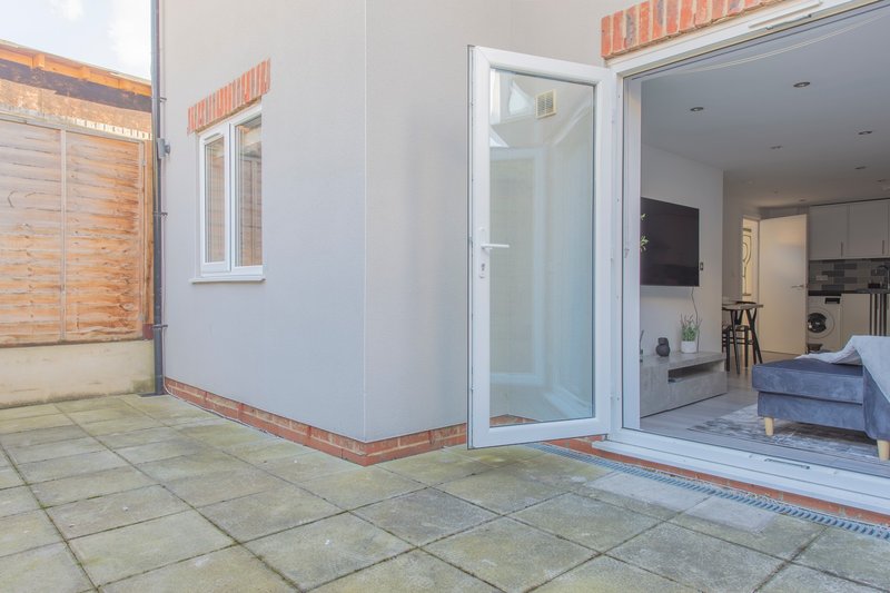 Modern patio with sliding glass doors opening to kitchen and living area