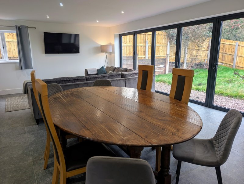 A large open-plan dining and living space with plenty of seating, making it ideal for groups. The generous dining table is perfect for shared meals.