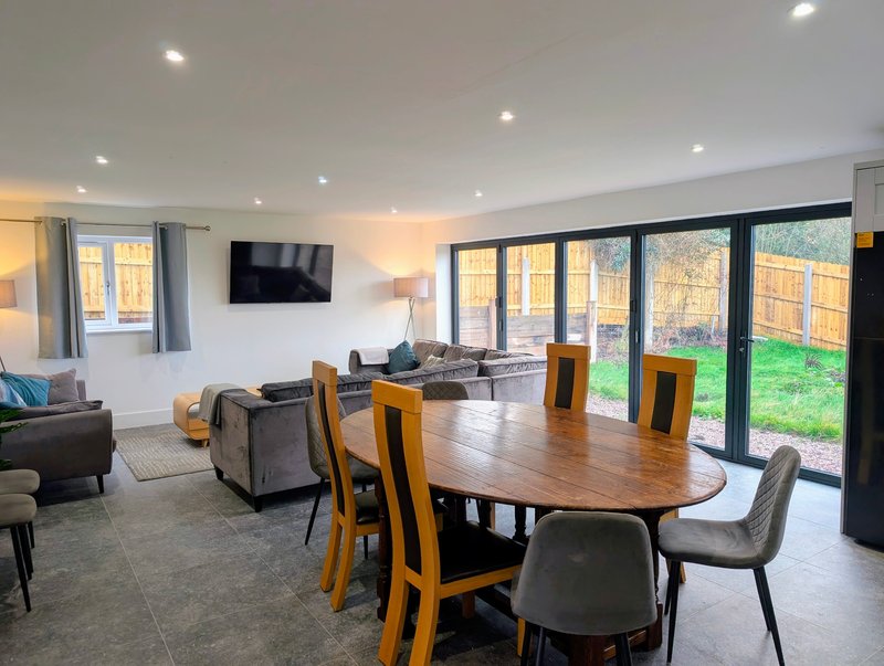 A spacious open-plan area with comfortable seating, a large dining table and TV, giving groups and contractors plenty of room to relax, socialise and enjoy meals together.