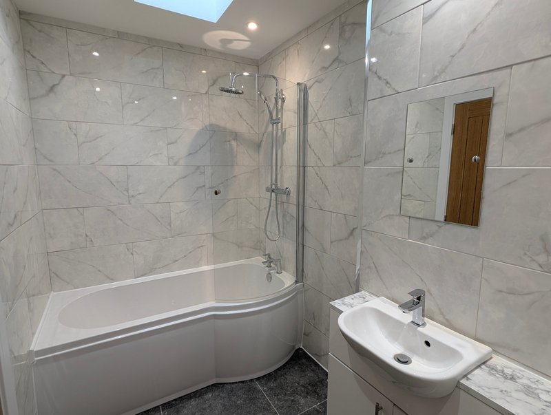 Modern, spacious bathroom with a shower over bath, ideal for guests and contractors looking for a comfortable, practical space to freshen up after a busy day.