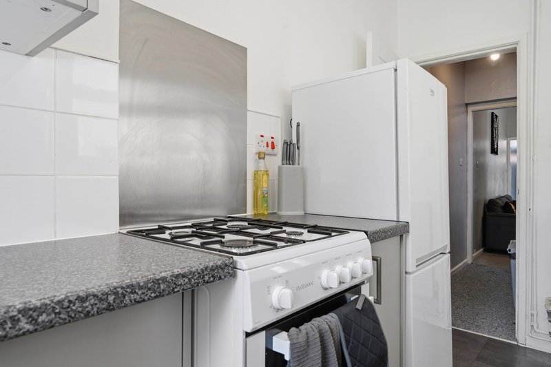 Modern kitchen with white appliances, gas cooktop, stainless steel splashback and granite countertop
