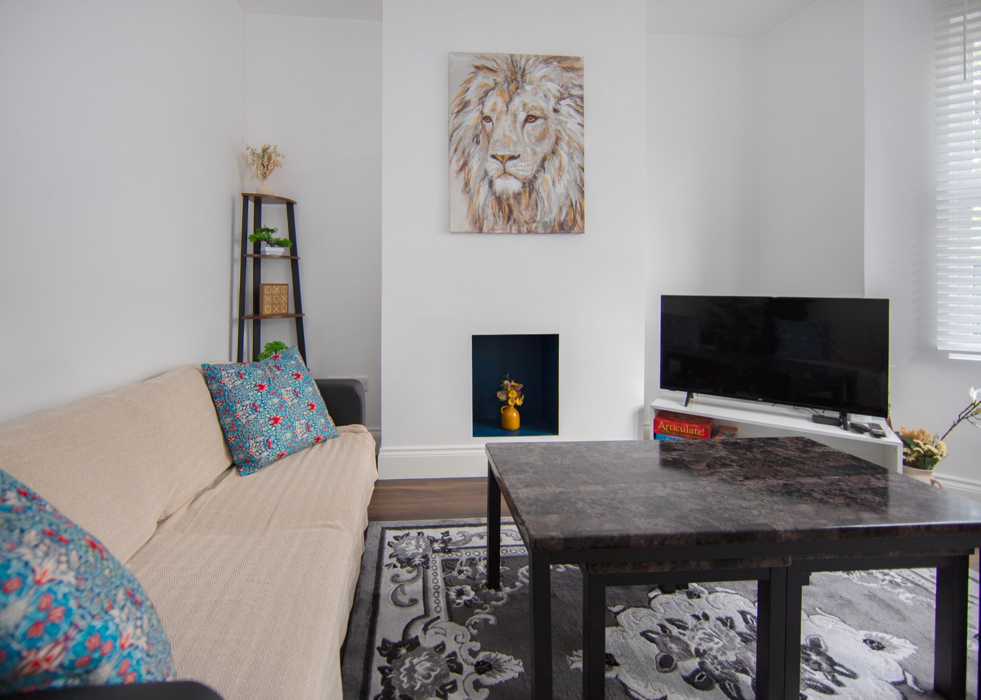 Modern living room with beige sofa, dark TV stand, fireplace insert and wall art