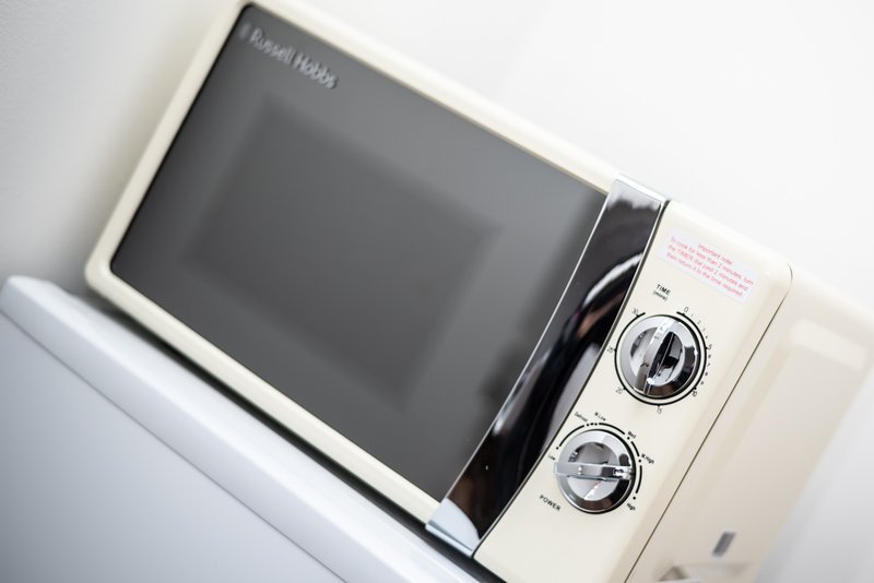 Russell Hobbs microwave with cream exterior and digital display on countertop
