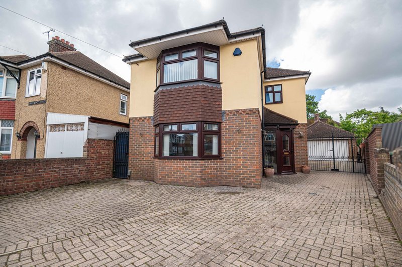 Modern two-story house with brick and rendered facade, driveway, and front garden