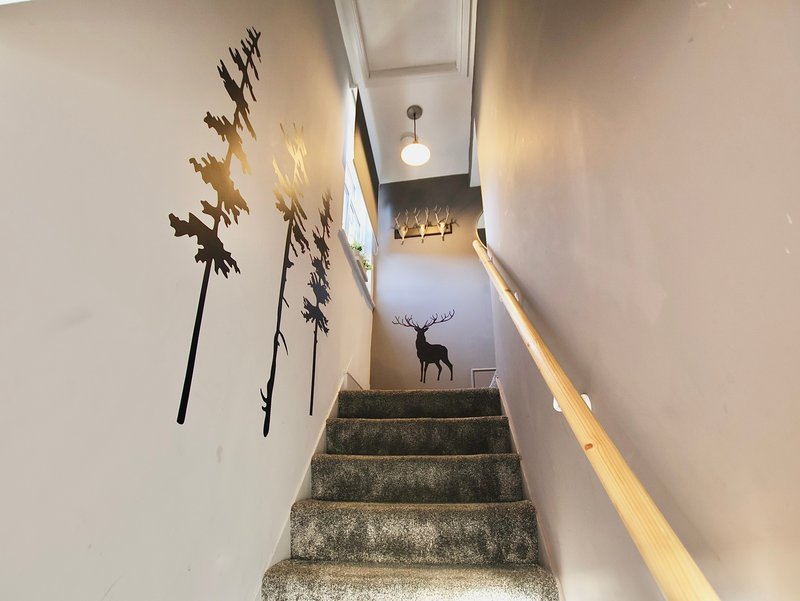 Staircase with wall art, handrail, and decorative deer silhouette