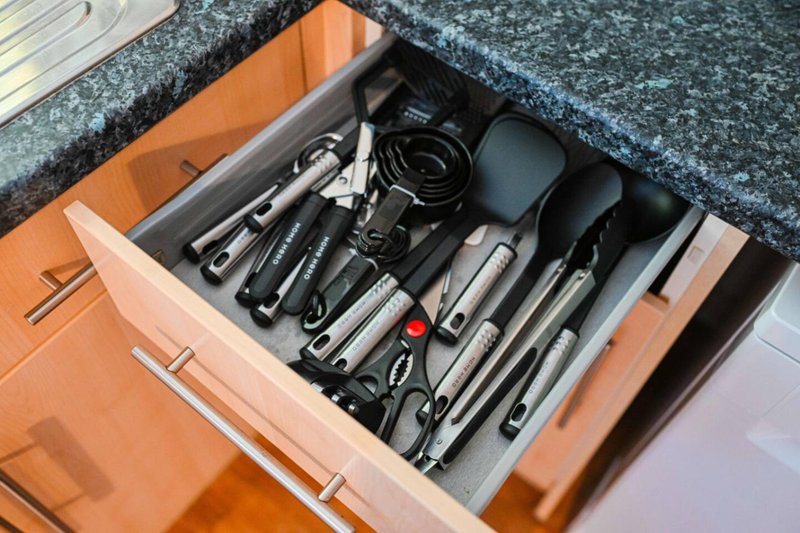 Kitchen drawer with organized hair styling tools and accessories neatly arranged