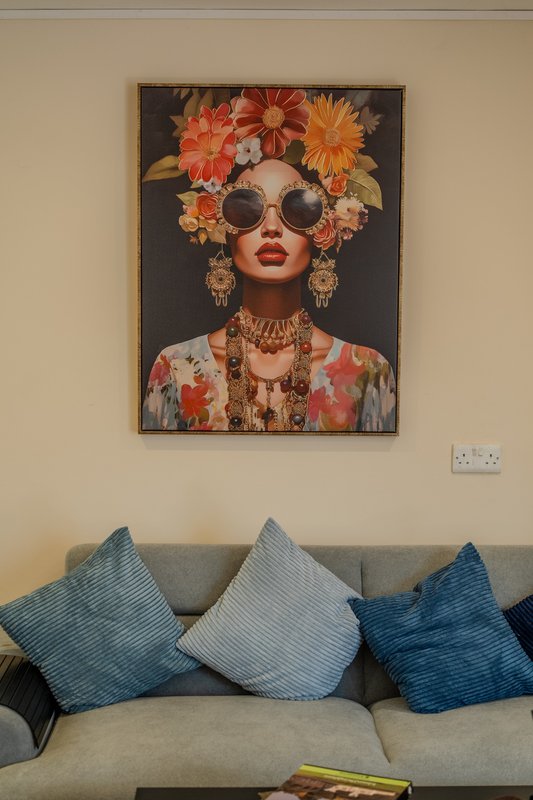 Living room with grey sofa, blue and grey cushions, and framed abstract art on wall