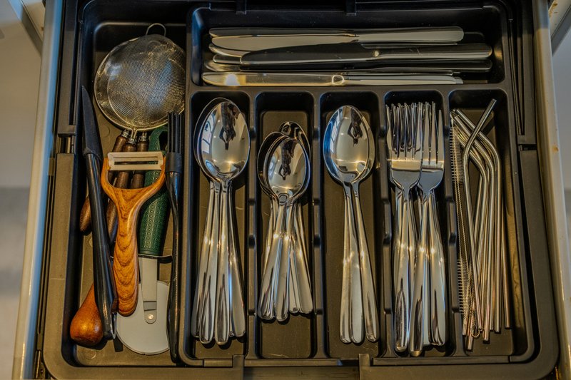 Organized kitchen drawer with cutlery, utensils, and serving implements neatly arranged