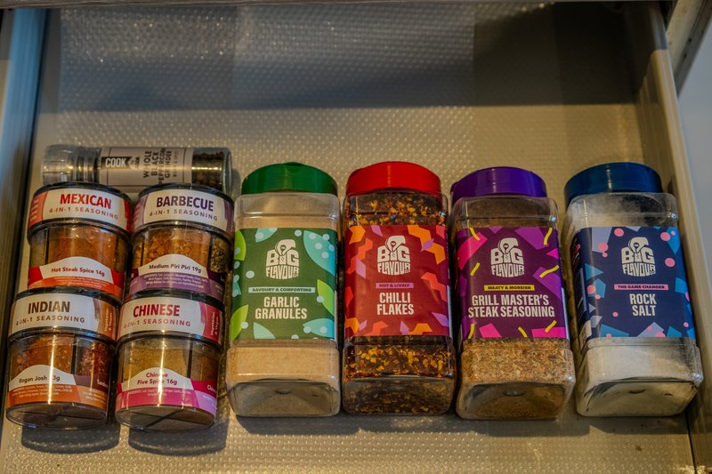 Kitchen drawer organizer with six jars of spices and seasonings neatly arranged