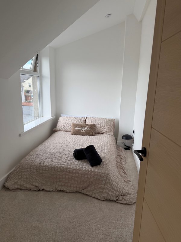Small double bed with hanging rails for storage of clothes