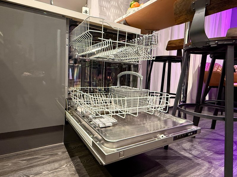 Modern kitchen with open dishwasher, stainless steel appliances and purple accent lighting
