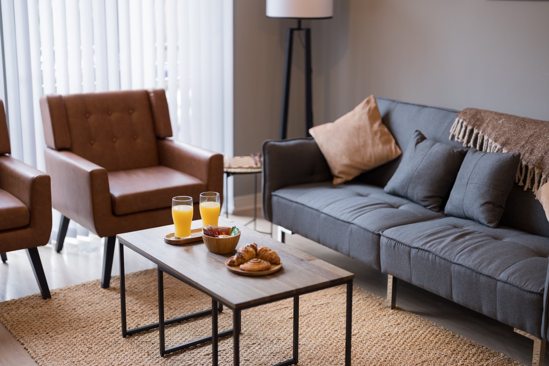 Modern living room with brown armchair, blue sofa, coffee table and floor lamp