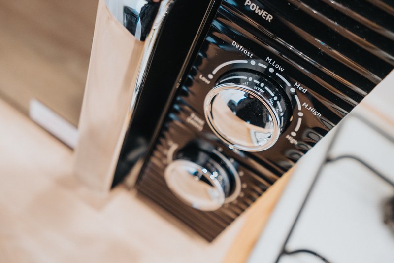 Close-up of kitchen appliance control panel with power button and temperature settings