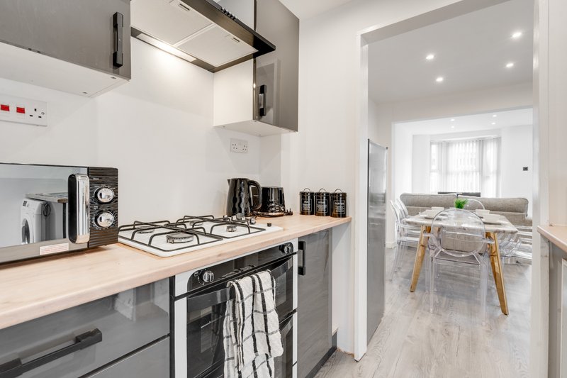 Modern kitchen with gas hob, stainless steel appliances, wooden worktops and dining area visible