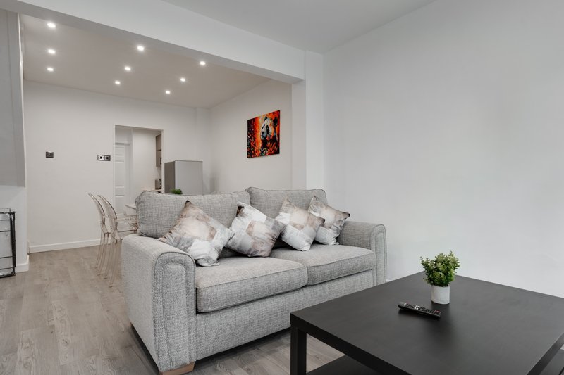 Modern living room with grey sofa, black coffee table, and recessed ceiling lights