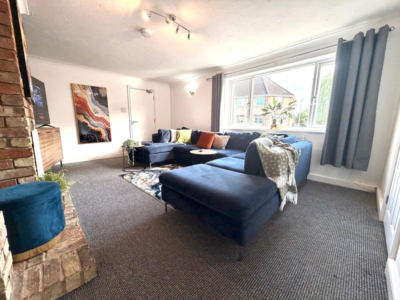 Spacious living room with blue sectional sofa, fireplace, large windows and modern decor