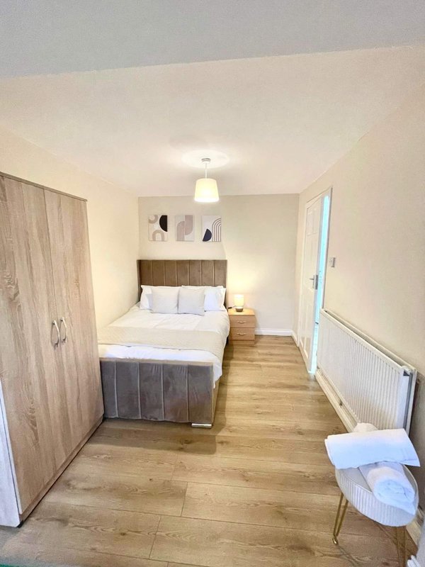 Bedroom with double bed, wooden flooring, wardrobe, and pendant light fixture