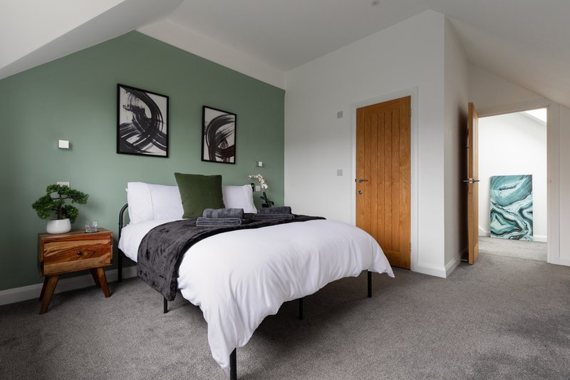 En-suite double bedroom with hanging rail and bedside drawers. Towels are provided for all guests.