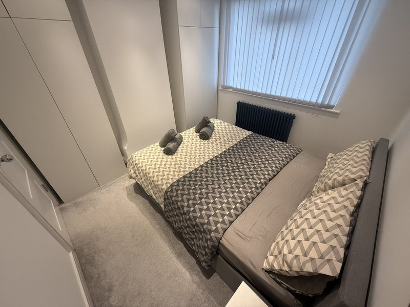 Compact bedroom with double bed, single bed, vertical radiator and skylight window