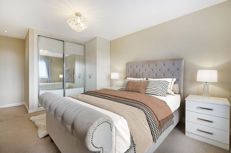 Modern bedroom with upholstered headboard, double bed, mirrored wardrobe and bedside lamps