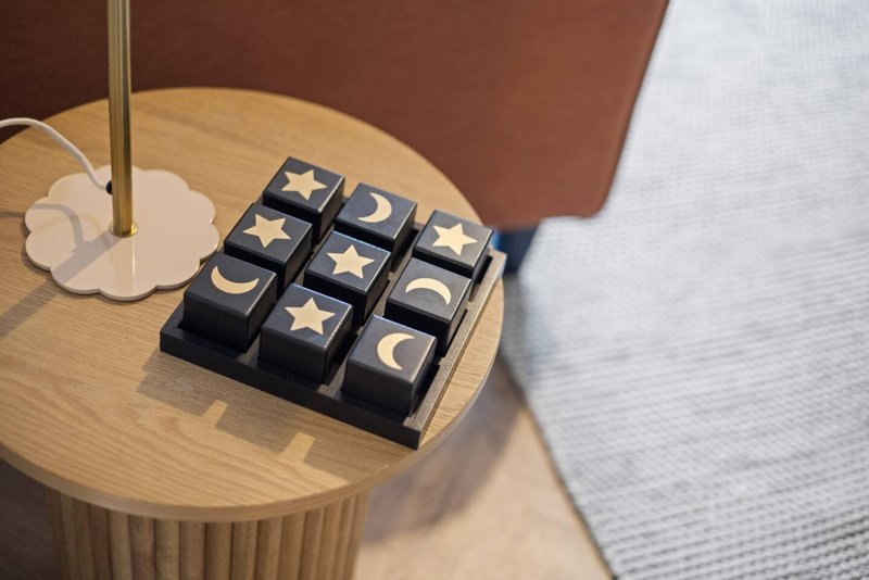 Wooden side table with decorative moon and star tile display and table lamp