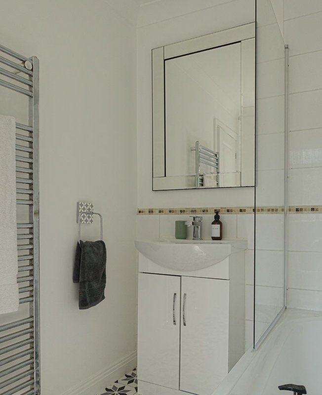 Modern bathroom with white vanity, mirror, towel rail and shower enclosure