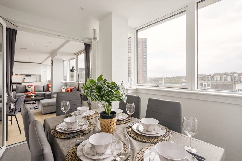 Modern dining table with place settings overlooking city skyline through large windows
