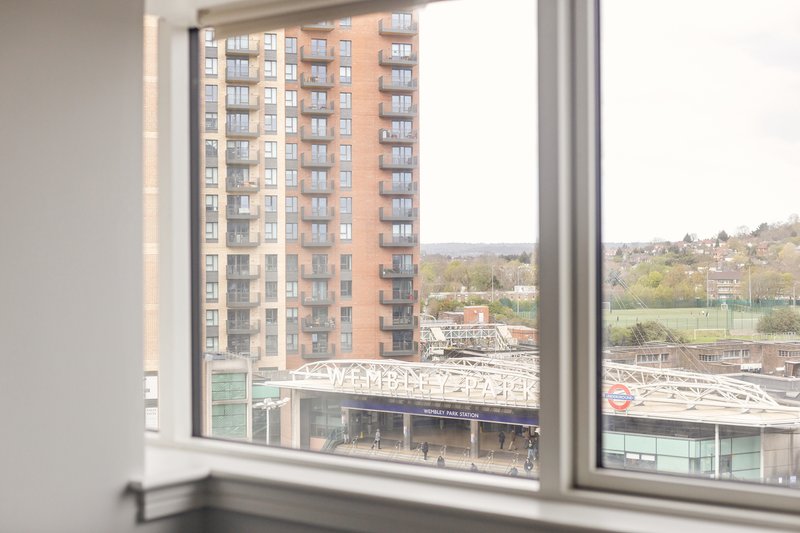 Window view of residential apartment building and urban landscape with hills in distance