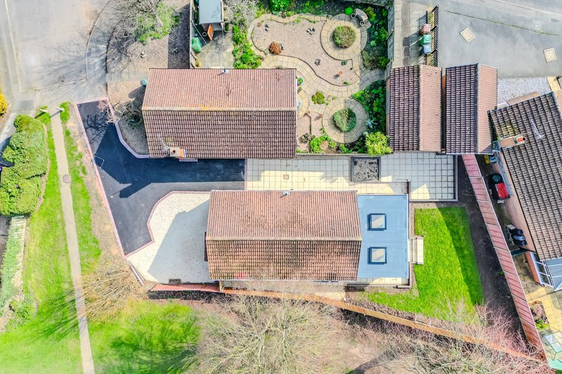 Aerial view of residential property with terracotta-roofed buildings, gardens, and driveway