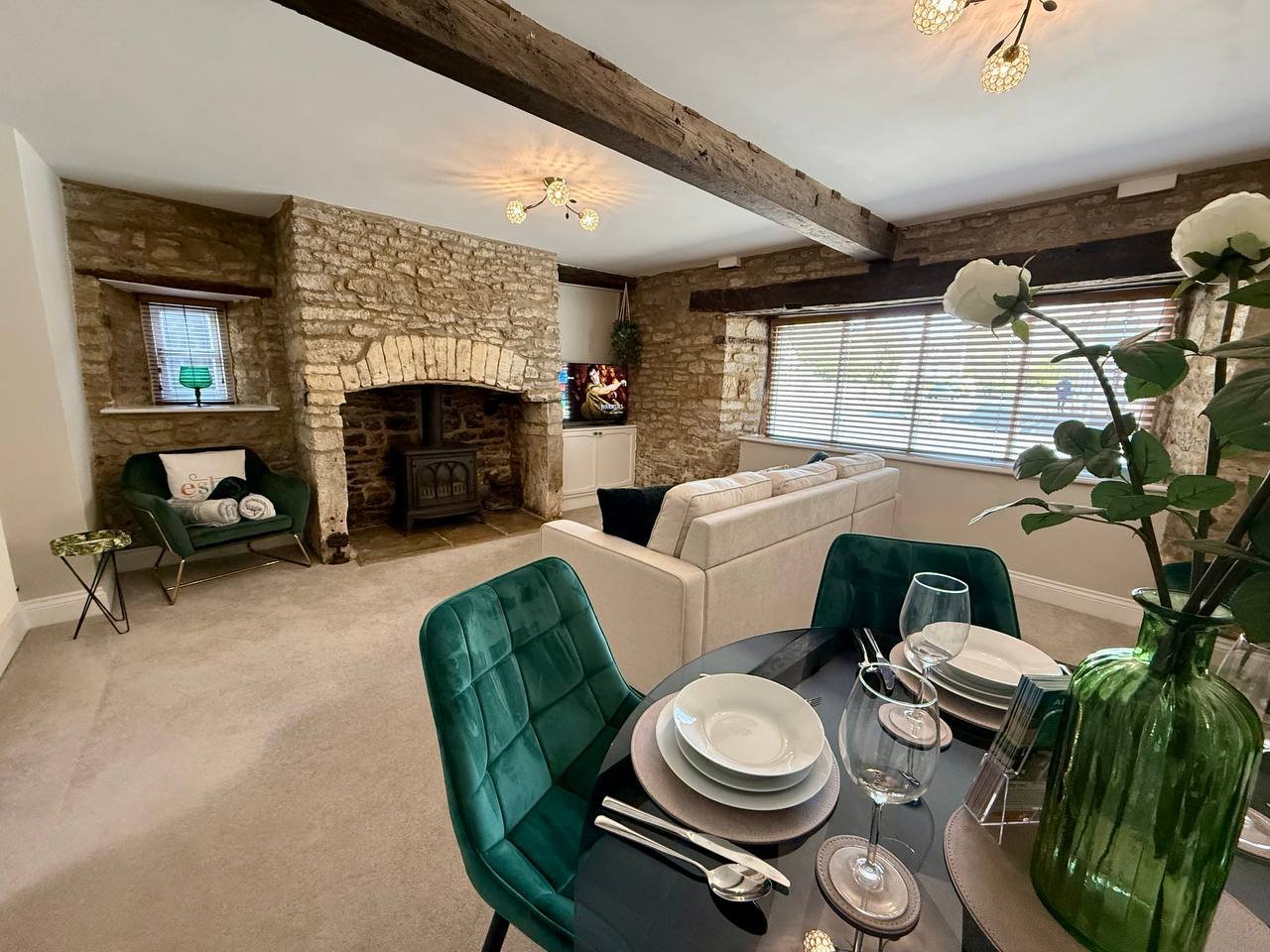 Open-plan living space with dining table, fireplace, sofa, and large windows