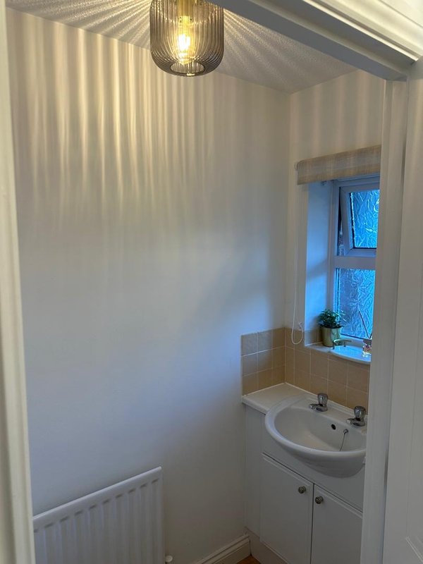 Small bathroom with sink, radiator, window and pendant light fixture