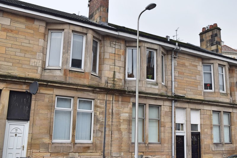 Stone terrace building exterior with multiple windows, white door and street lamp