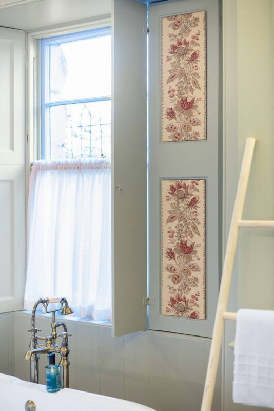 Bathroom with window, sink, bathtub, floral wall art, and towel rack