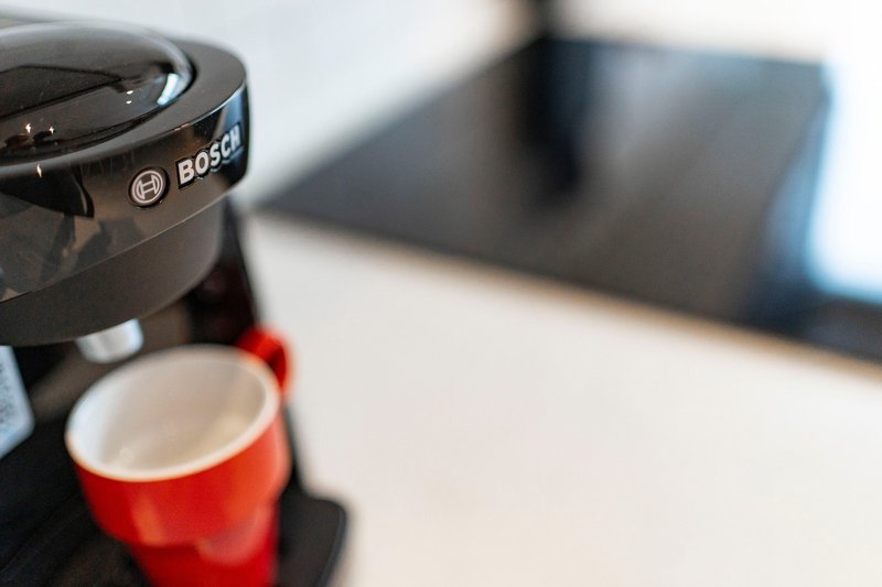 Bosch coffee maker with red cup on kitchen counter