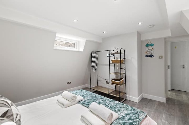 Attic bedroom with double bed, metal shelving unit, and sloped ceiling