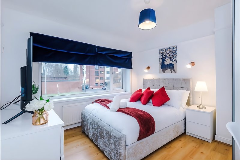 Master bedroom with large King sized bed and also a 50"  smart TV, storage and a dedicated work area
