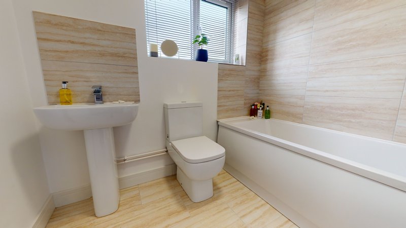 Modern bathroom with pedestal sink, toilet, bathtub, wooden flooring and light wood wall paneling