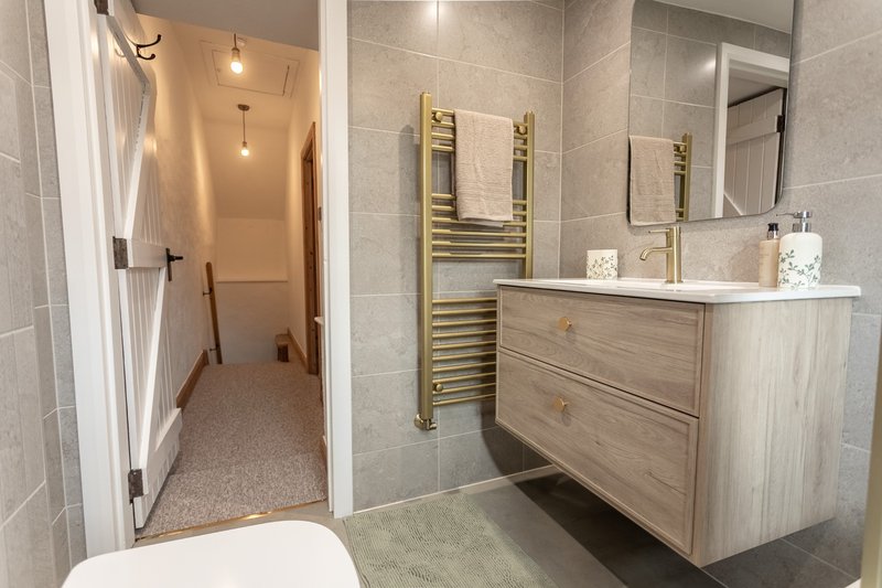Modern bathroom with vanity unit, heated towel rail, mirror and shower enclosure