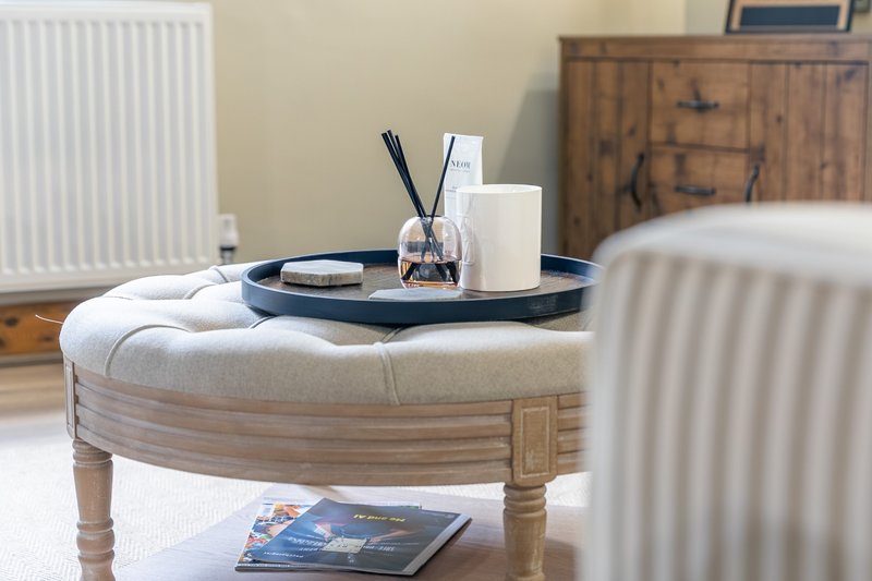 Bedroom with upholstered ottoman, decorative tray, radiator and wooden furniture