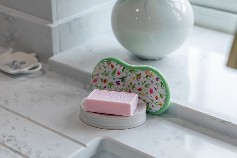 Bathroom counter with soap, decorative dish, and white ceramic sphere ornament