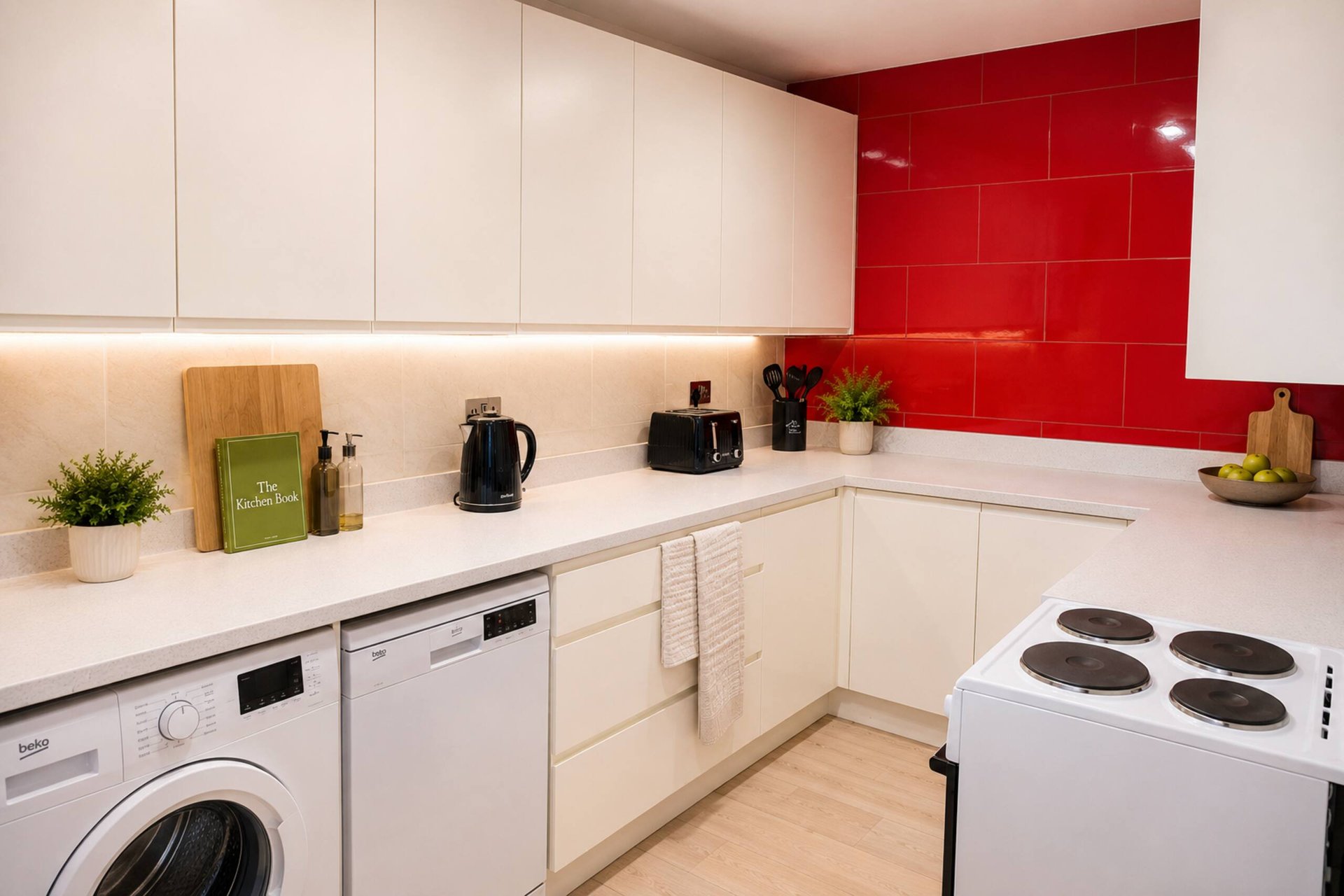 Modern kitchen with white cabinetry, red tile backsplash, white appliances and wooden countertop accessories