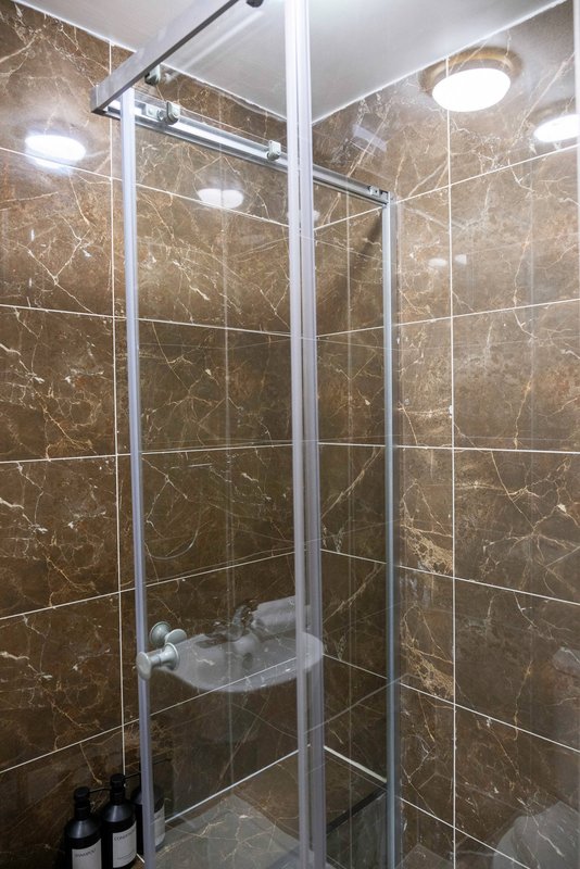 Modern bathroom with large walk-in shower, marble-effect tiling and chrome framing