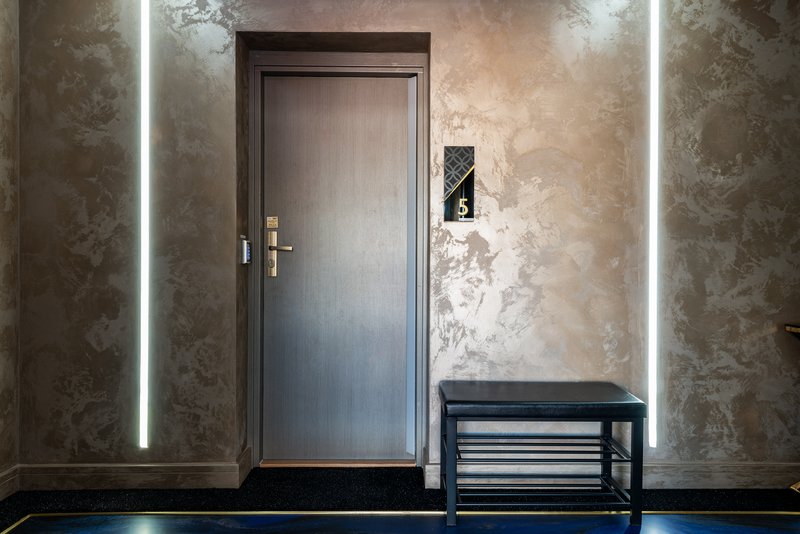 Modern entryway with gray door, neon wall lighting, textured wallpaper and shoe rack